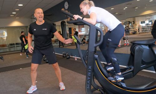 Man shouting at a woman on a treadmill.